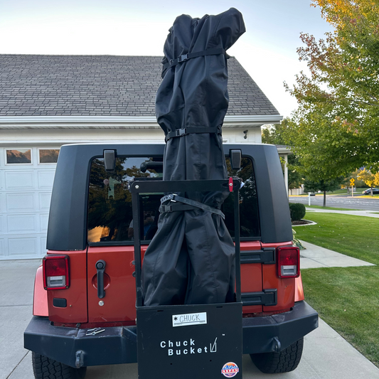 Red Jeep with a ski cargo hitch rack, chuck bucket, attached. With a Ski cover holding the skis.