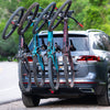 A vertical 4-bike rack mounted on the rear of a car, featuring adjustable handlebar hooks and carrying two bikes.