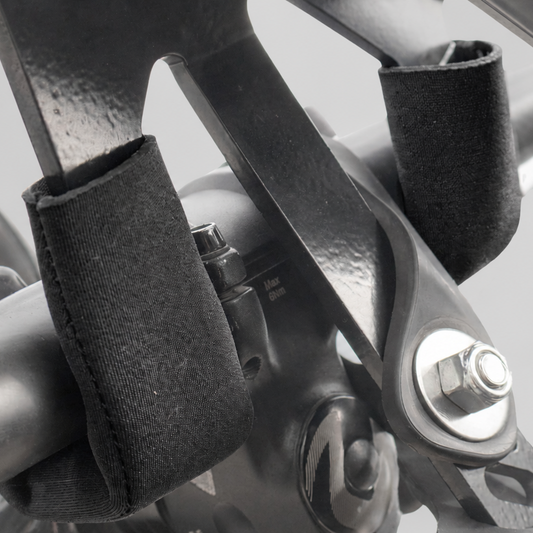 Close-up of a bike rack padding for handlebar. strap holding a black handlebar grip in place on a bicycle's stem.